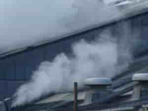 煙突から煙が出ている企業の屋根