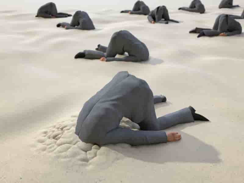 砂の中に頭をうずめるビジネスマンたち